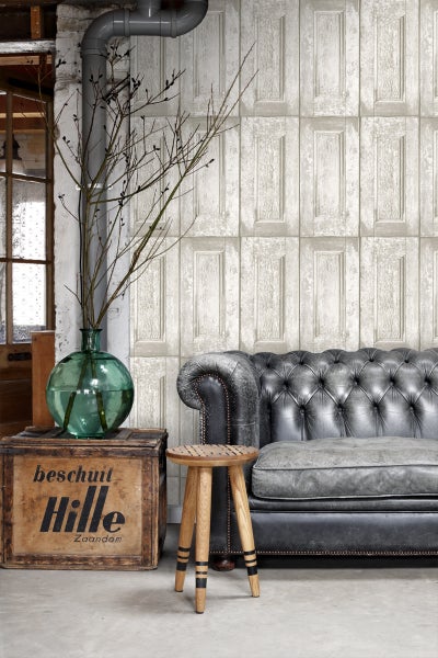 Wohnzimmer mit Sofa, Holzhocker, Dekoration und Wandtapete mit Türmotiv