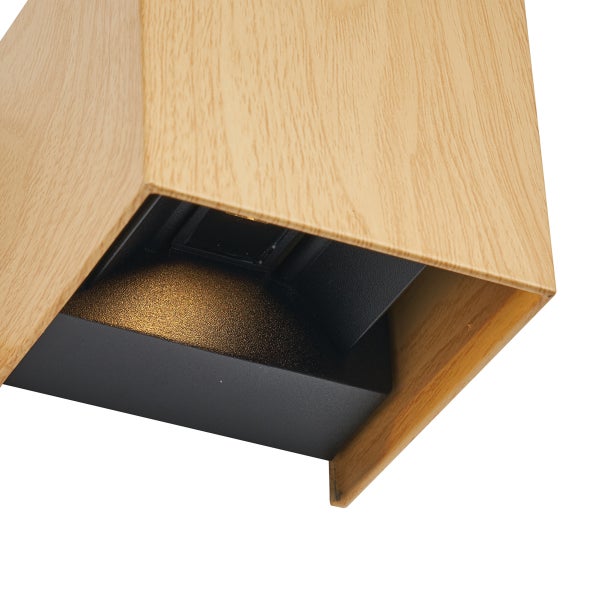 Moderne Wandleuchte aus Holz in Würfelform mit schwarzer Innenseite und integriertem Leuchtmittel für den Innenbereich.