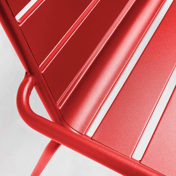 Nahaufnahme eines roten Gartenstuhls aus Metall mit Lamellen und einem Rohrrahmen.