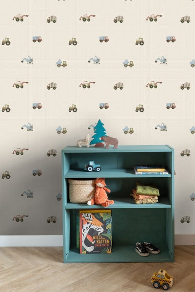 Kinderzimmer mit gemusterter Tapete mit kleinen Baustellenfahrzeugen, einem blauen Regal mit Spielzeug und hellem Holzfußboden.