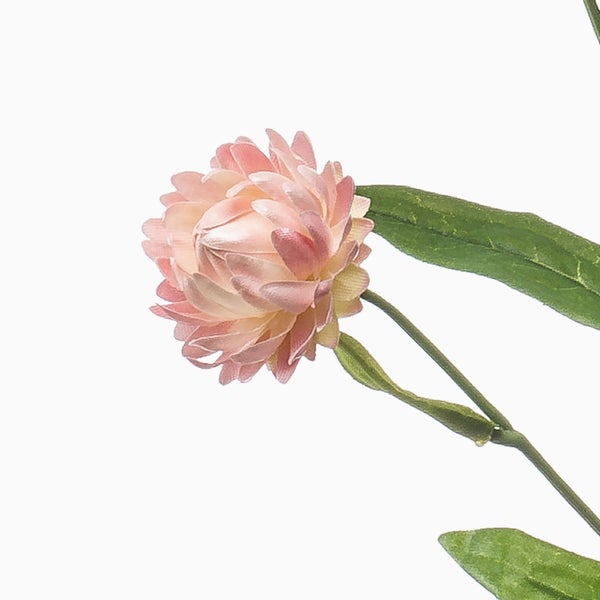 Detailansicht eines künstlichen Pflanzenstiels mit schmalen grünen Blättern.