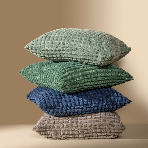 Stapel aus vier strukturierten dekorativen Kissen in verschiedenen Farben