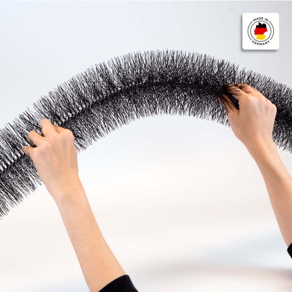 Flexible Dachrinnenbürste aus schwarzem Kunststoff, wird von Händen gehalten und gebogen, mit Siegel Hergestellt in Deutschland.