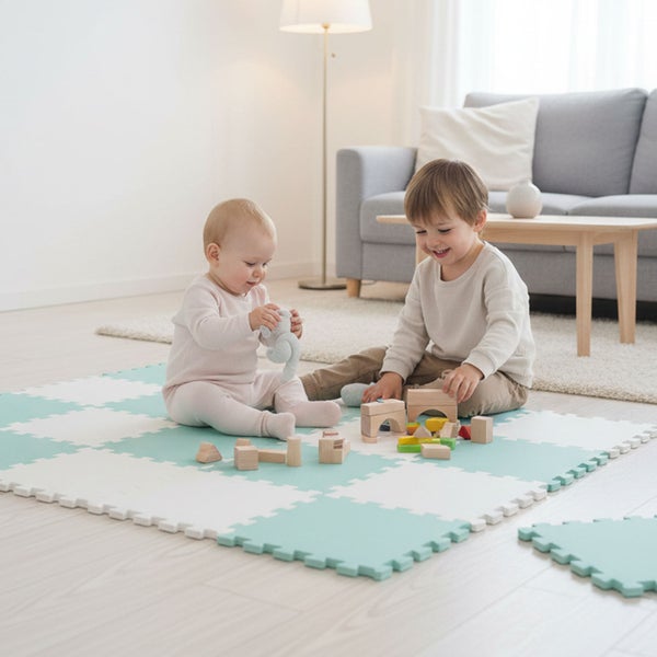 Helle, organisierte Wohnzimmerszene mit zwei Kindern, die auf einer weichen Schaumstoff-Puzzlematte mit Holzbausteinen spielen.