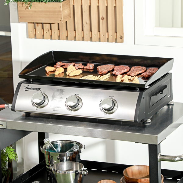 Outsunny Gasgrill mit drei Brennern und Grillplatte auf einem Edelstahlwagen, belegt mit Grillgut in einer hellen, organisierten Außenumgebung.