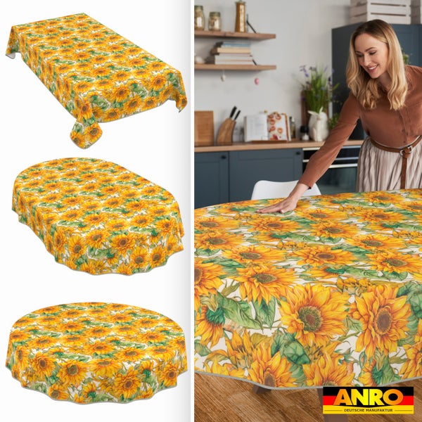 Wachstuch Tischdecke mit Sonnenblumen-Muster in rechteckig, oval und rund, Frau legt Decke in Küche auf, ANRO Deutsche Manufaktur Logo.