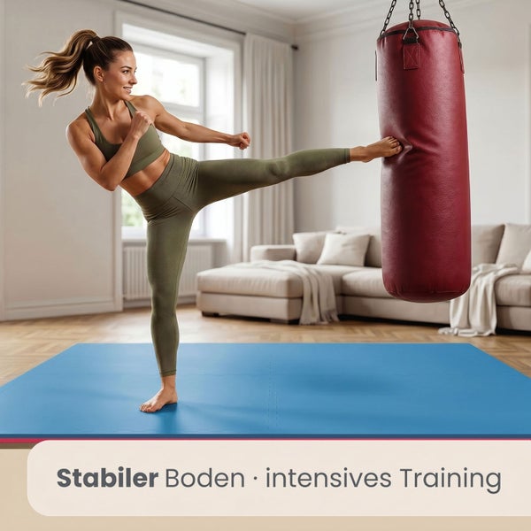 Eine Frau trainiert Kickboxen auf einer Fitnessmatte in einem hellen, geräumigen Wohnzimmer mit einem Boxsack.