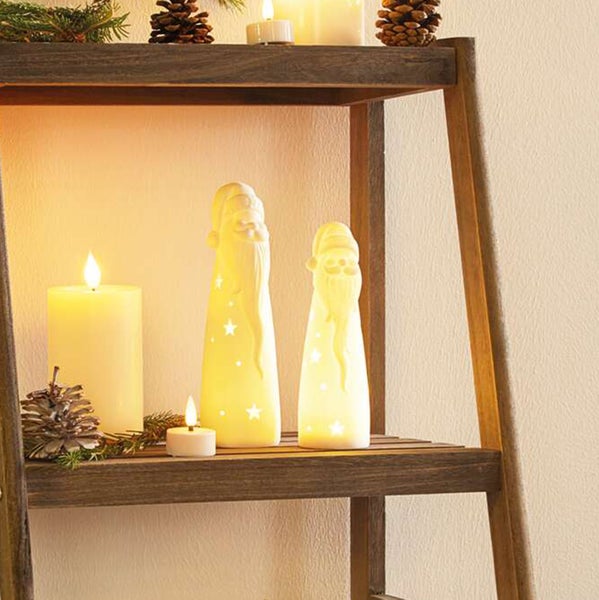 Dekorative Holzleiter mit leuchtenden Weihnachtsmannfiguren und Kerzen