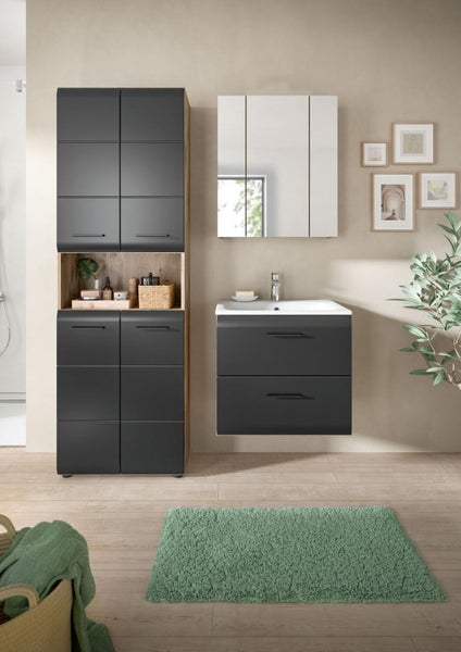 Modernes Badezimmer mit dunkelgrauem Waschtisch, Hochschrank mit Holzregal, Spiegelschrank und grünem Vorleger auf hellem Holzboden.