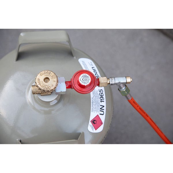 Gasflaschenanschluss mit Druckregler, Ventilrad und angeschlossenem Gasschlauch.