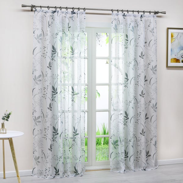 Dekorative, transparente Gardine mit Pflanzenmuster vor einem Fenster.