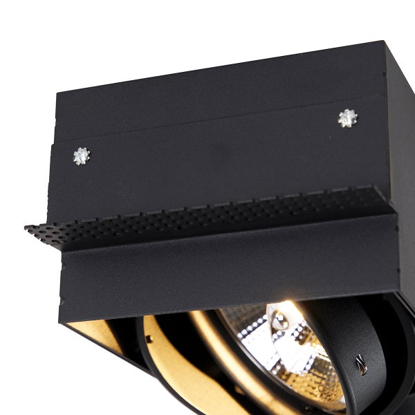 Nahaufnahme eines quadratischen schwarzen Deckenstrahlers mit verstellbarem goldfarbenem Innenring und perforierter Metallkante.