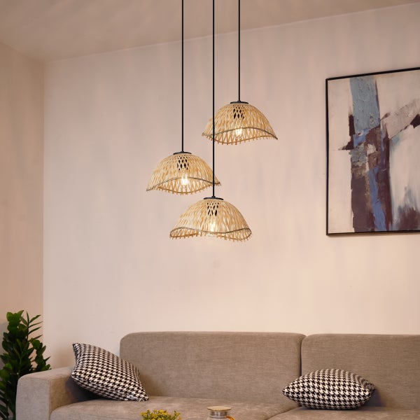 Hängeleuchte aus Rattan mit drei Lampen über einem Sofa