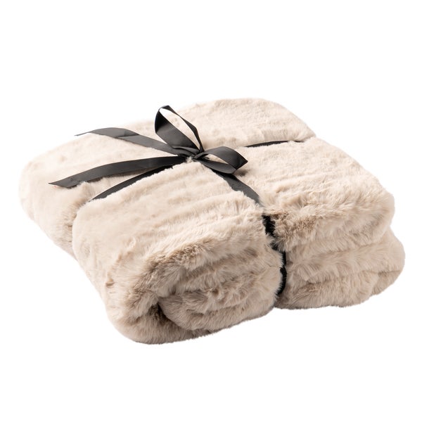 Gefaltete beige Kuscheldecke aus Kunstfell mit schwarzer Schleife