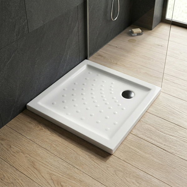Quadratische Duschwanne mit Antirutsch-Noppen vor Wandfliesen aus Naturstein und Boden in Holzoptik in einem modernen Badezimmer.