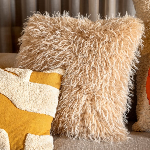 Dekorative Kissen mit Fellstruktur und geometrischen Mustern