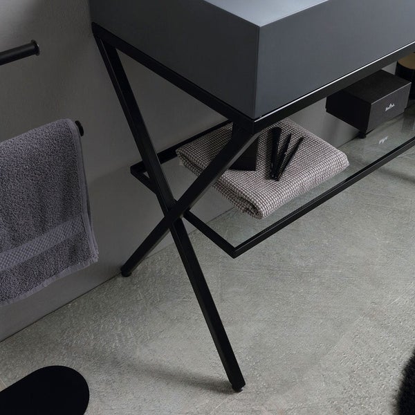 Waschtisch mit Handtuch und Badutensilien auf Glasablage