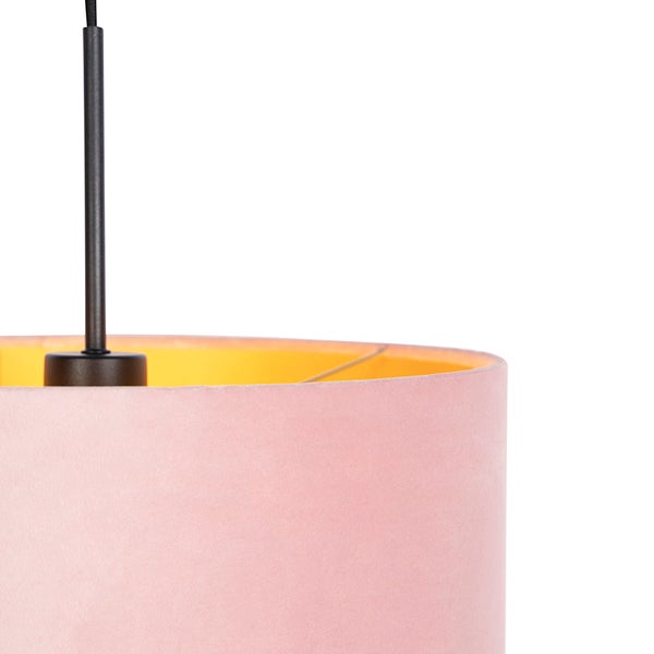 Detailansicht einer Pendelleuchte mit zylindrischem Lampenschirm aus rosa Samt und gelber Innenseite.