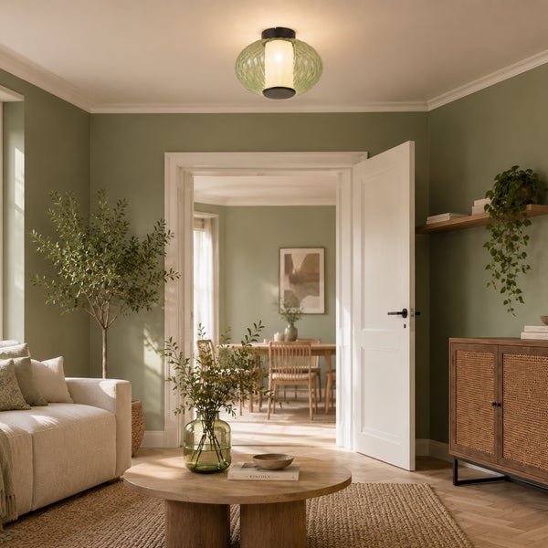 Deckenleuchte mit geripptem Glasschirm in einem modern eingerichteten Wohnzimmer mit grünen Wänden.