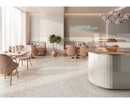 Heller Raum mit Terrazzoboden, Tischen, Stühlen und einer Verkaufstheke mit Backwaren