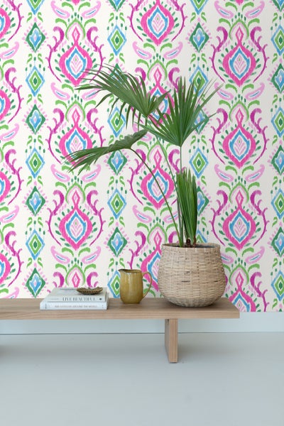 Dekorative Tapete mit farbenfrohem Muster auf einer Akzentwand in einem hellen Raum.
