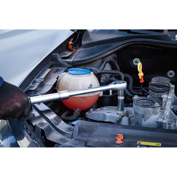 Ein Mechaniker verwendet eine Ratsche zum Reparieren eines Automotors.