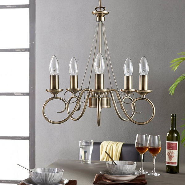 Messingfarbene Deckenleuchte mit fünf Leuchten über einem Esstisch