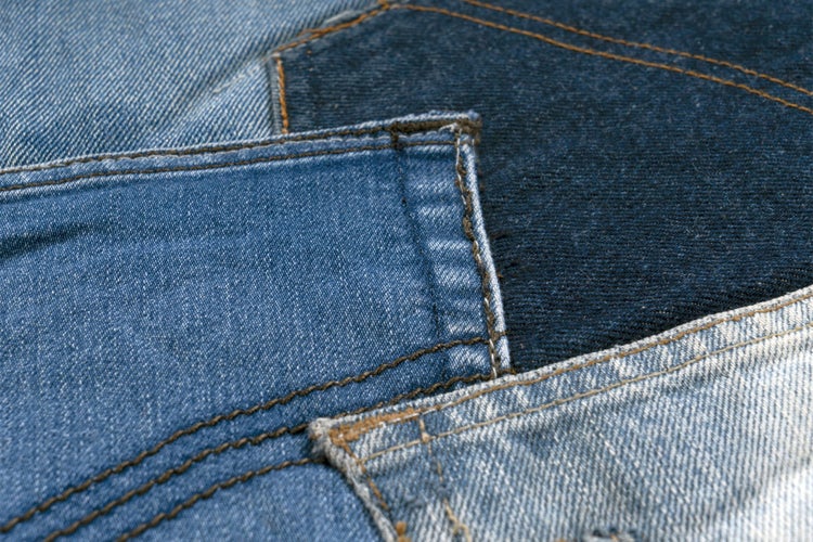 Nahaufnahme verschiedener Jeans Stoffe mit sichtbaren Nähten und unterschiedlichen Texturen als Arbeitskleidung