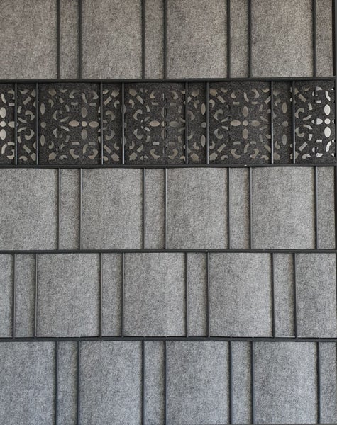 Nahaufnahme einer grauen Akustikwand mit dekorativem Muster