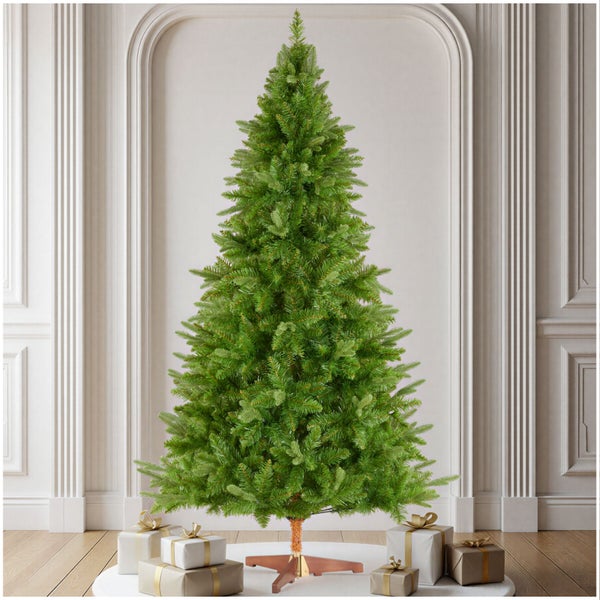 Künstlicher Weihnachtsbaum mit einer Tannenoptik, stehend auf einem stabilen Ständer in einem eleganten Raum mit verpackten Geschenken.