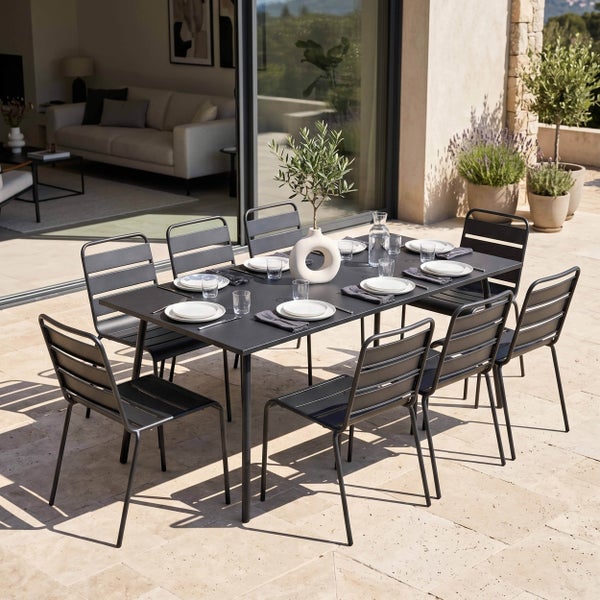 Gartenmöbel-Set aus Metall mit einem rechteckigen Tisch und acht Stühlen auf einer hellen Terrasse.