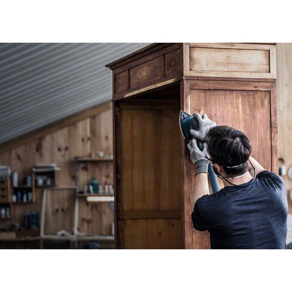 Mann schleift Holzschrank mit einem Schleifgerät