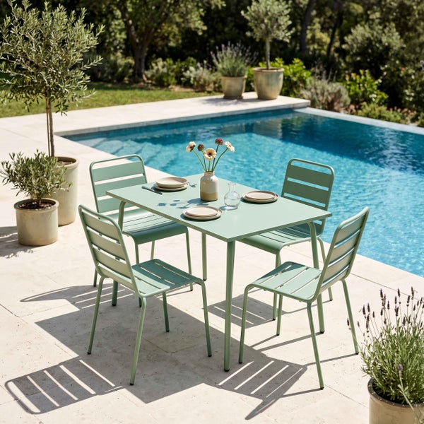 Modernes Gartenmöbel-Set aus Metall mit rechteckigem Tisch und vier Stühlen auf einer hellen Steinterrasse an einem Swimmingpool mit Pflanzen.