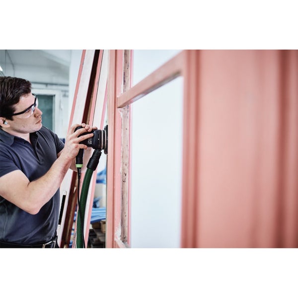 Person schleift einen Holzrahmen mit einem elektrischen Schleifgerät und Staubabsaugung.