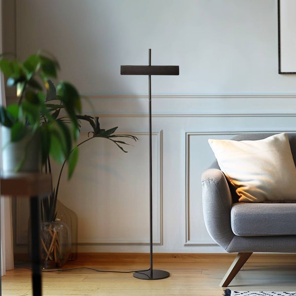 Stehleuchte im Wohnzimmer neben einem Sofa und einer Zimmerpflanze.