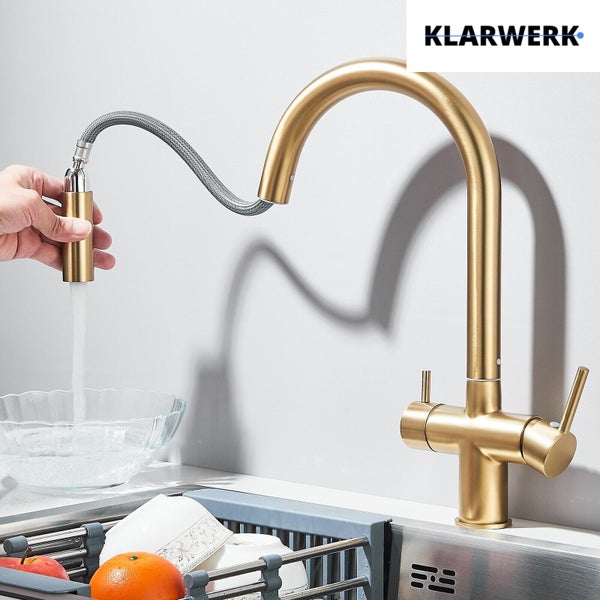 Goldfarbene Küchenarmatur von Klarwerk mit ausziehbarer Brause und zwei Hebeln an einer Spüle montiert. Klarwerk Logo.