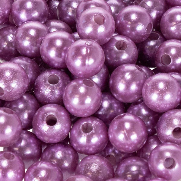 Haufen von violetten Wachsperlen mit Loch für Bastelarbeiten und Schmuckherstellung