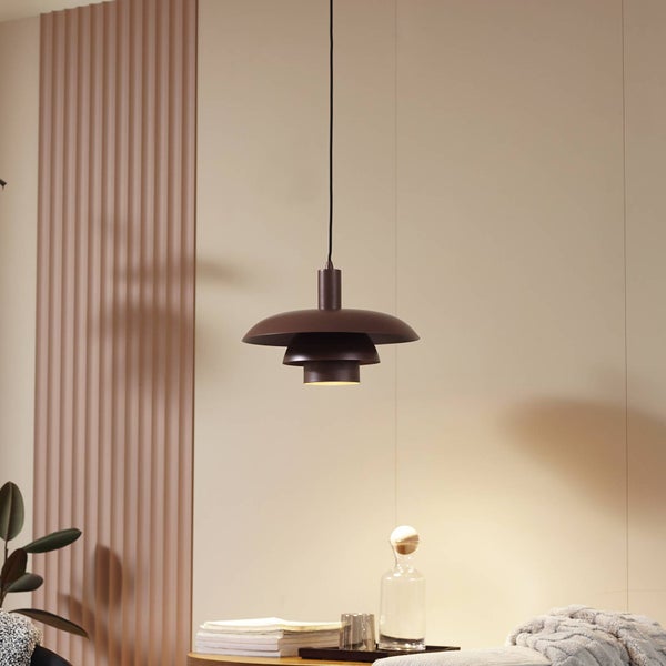 Moderne, mehrstufige Pendelleuchte in Braun über einem Beistelltisch in einem hellen, modern gestalteten Wohnraum.