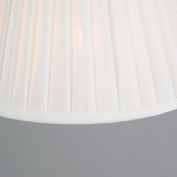 Nahaufnahme eines Lampenschirms aus plissiertem weißem Stoff.