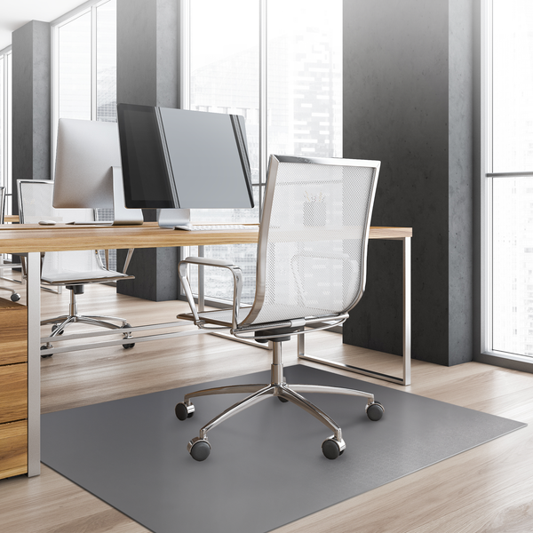 Helles modernes Büro mit Holzschreibtisch, Netz-Bürostuhl und grauer Bodenschutzmatte auf Holzfußboden.