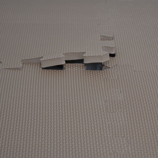 Ineinandergreifende Schaumstoff-Bodenmatten mit strukturierter Oberfläche und Puzzle-Verbindung.