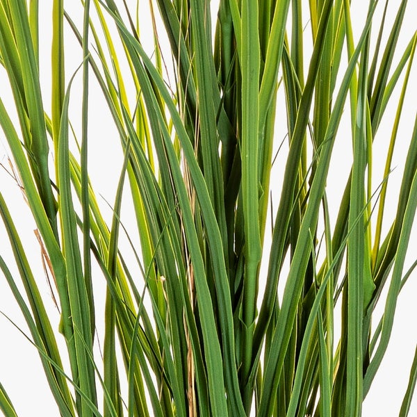 Nahaufnahme von grünen künstlichen Grashalmen einer Kunstpflanze.