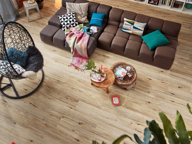 Wohnzimmer mit Ecksofa, Hängesessel und Holzboden im Vogelperspektive Blickwinkel.