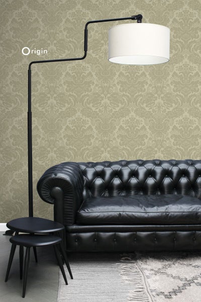 Einrichtungsidee mit einem schwarzen Ledersofa, einem Beistelltisch, einer Stehlampe und einer gemusterten Tapete.