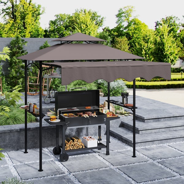Moderner Grillpavillon mit Doppeldach und Seitenmarkise über einem Holzkohlegrill auf einer Steinterrasse im Garten.