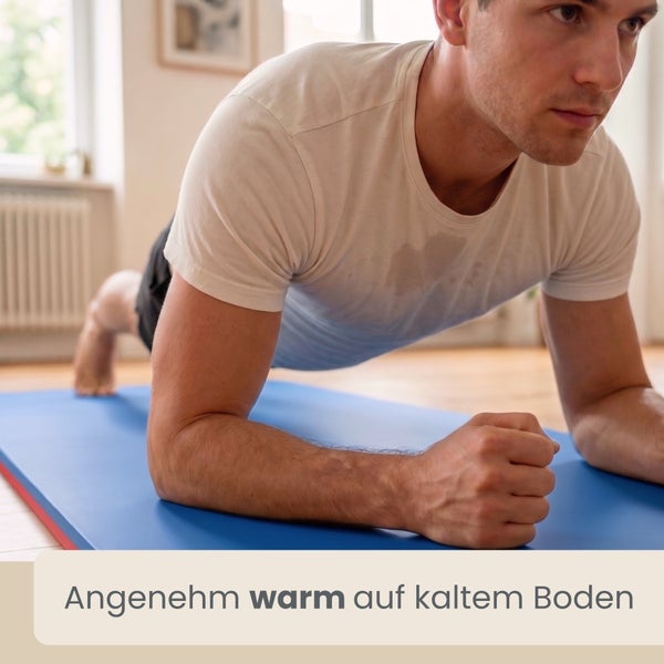 Mann beim Unterarmstütz auf einer blauen Fitnessmatte auf Holzboden in hellem Raum. Text: Angenehm warm auf kaltem Boden.