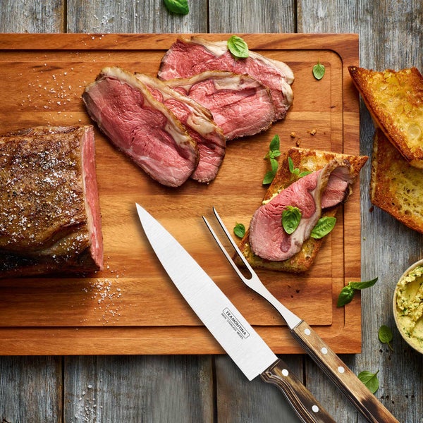 Holzschneidebrett mit Fleisch, Messer und Gabel