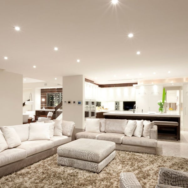 Modernes offenes Wohnzimmer und Küche mit Deckeneinbaustrahlern, großen Stoffsofas, einem Hochflor-Teppich und einer Frühstücksbar.