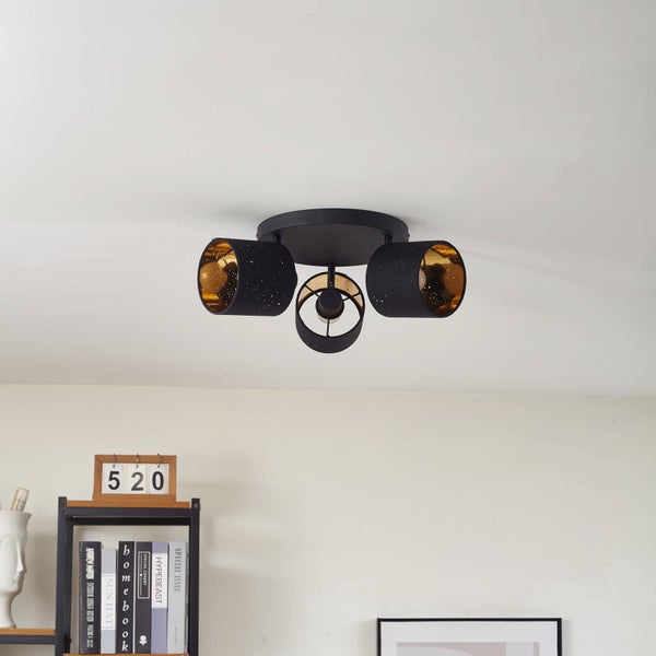 Dreiflammige Deckenleuchte in Schwarz mit goldfarbener Innenseite und Sterneneffekt-Perforation, montiert an einer weißen Zimmerdecke.