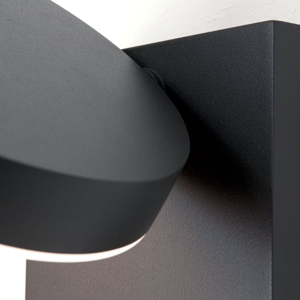 Nahaufnahme einer schwarzen Wandleuchte aus Metall mit matter, strukturierter Oberfläche und verstellbarem Lampenkopf.